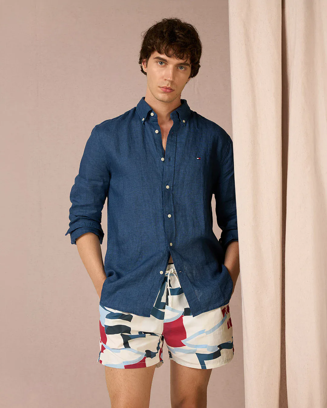 Close-up in a dark blue shirt and swimsuit, cream background