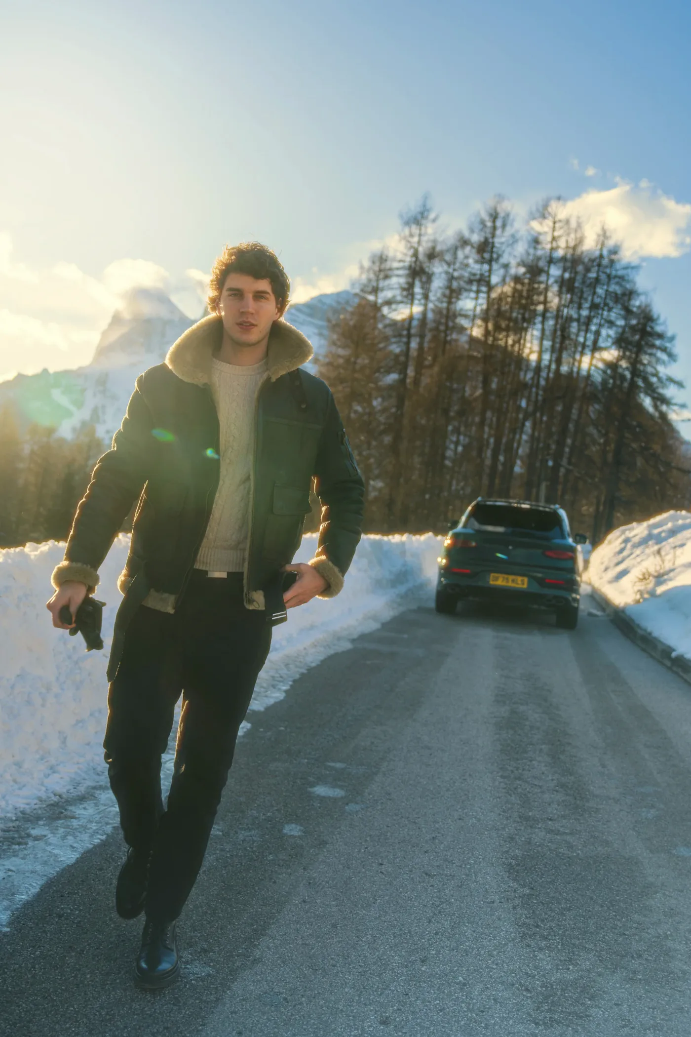 Francesco Scarparo walks backlit along a snowy road in Cortina
