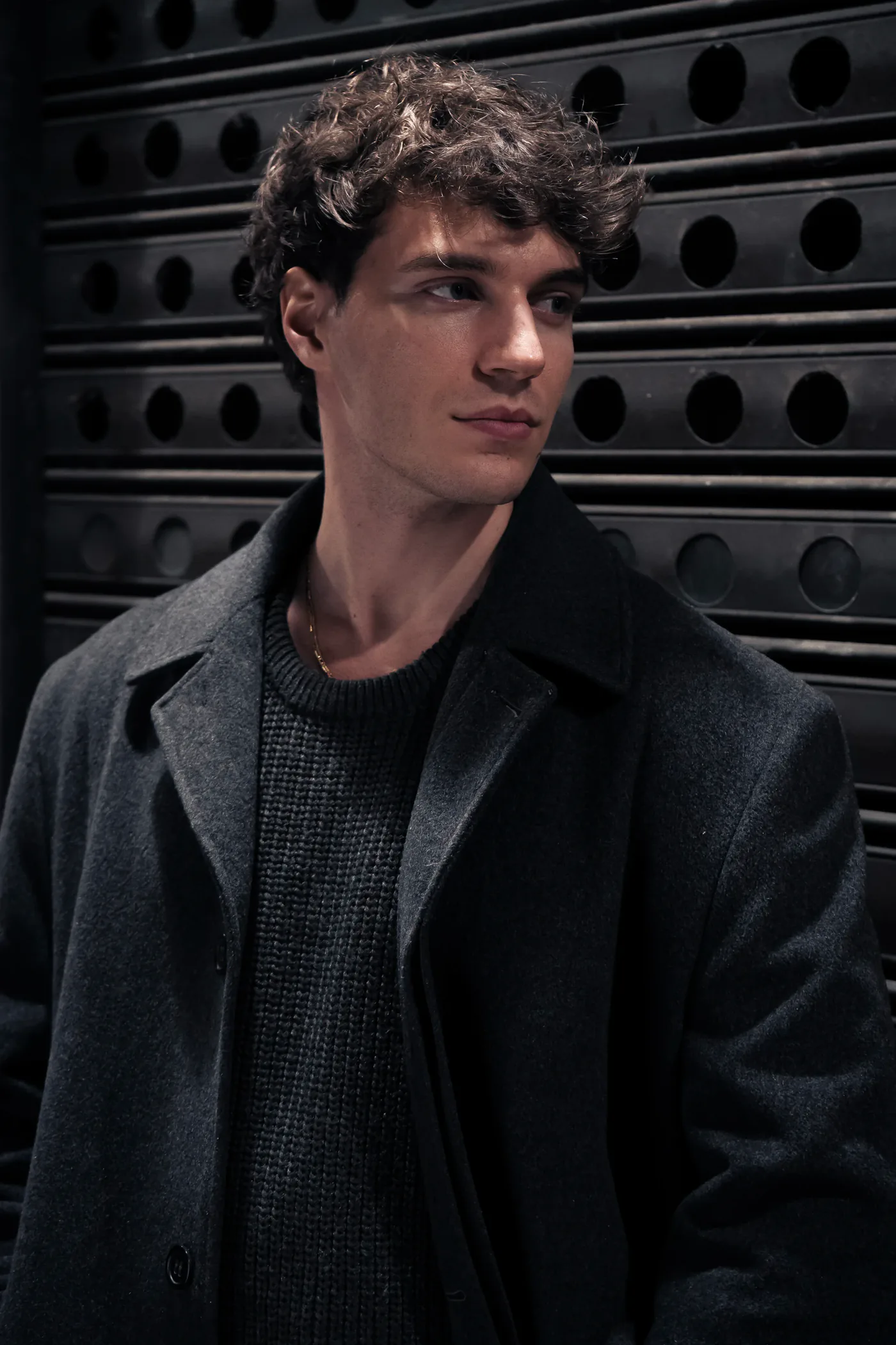 Francesco Scarparo in a wool coat in front of a dark shutter